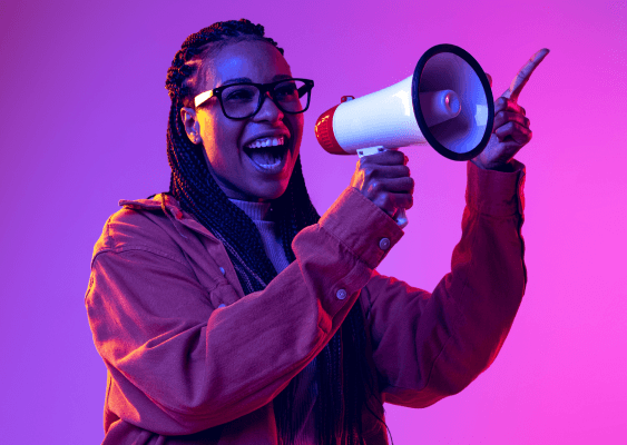 mulher sorrindo enquanto fala com megafone